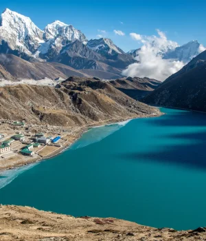 small-town-near-blue-body-water-surrounded-by-beautiful-mountains